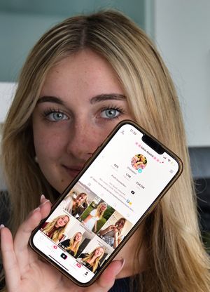 Sina-Marie Reen hält ihr Handy vor ihr Gesicht und zeigt drauf ihren Tiktok Account